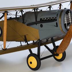 Model biplane aeroplane painted mustard brown with grey engine. Three quarter right view, engine section.
