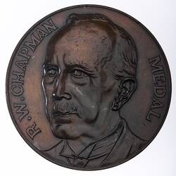 Round medal with 3/4 male portrait bust facing left, text around.