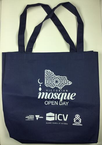 Navy tote bag with white printing.
