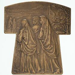 Bronze tau (t-shaped) medal, draped women in mourning follow a path to church.