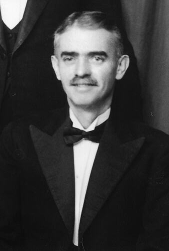 Smiling man poses wearing a tuxedo.