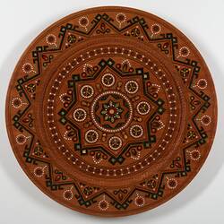 Round timber serving plate with detailed inlay work.