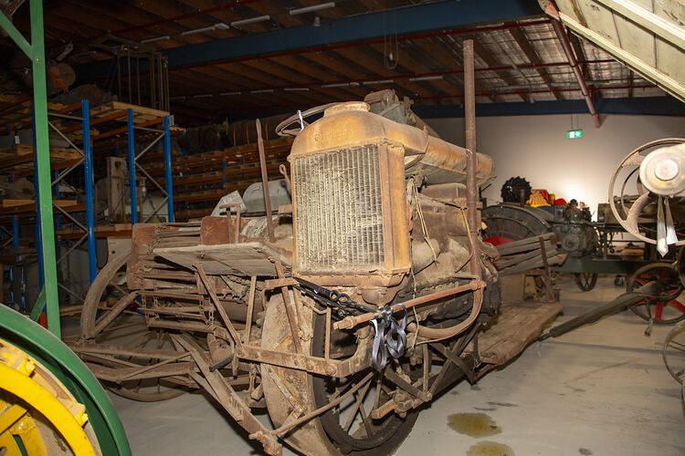 Weathered, worn self-propelled harvester with standard front, pick-up front, rice front and pea front.