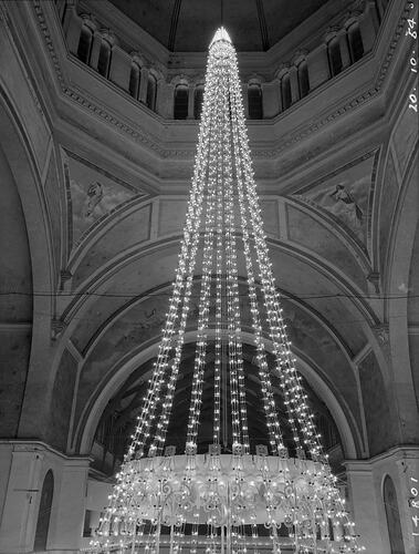 Conical display of lights inside an ornate building.