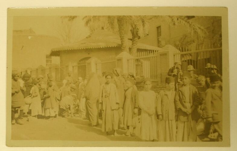 Crowd of people adjacent to building.
