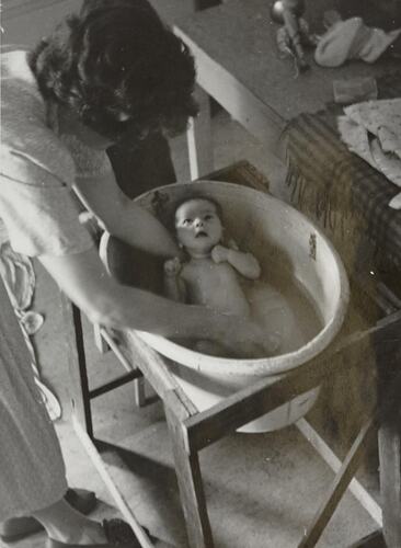 Digital Photograph - Woman Giving Baby First Bath at Home, Nunawading, 1951