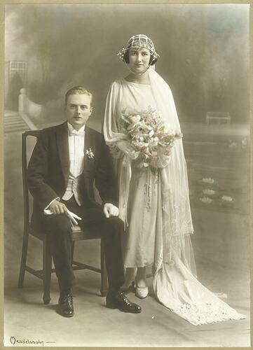 Seated groom and standing bride.