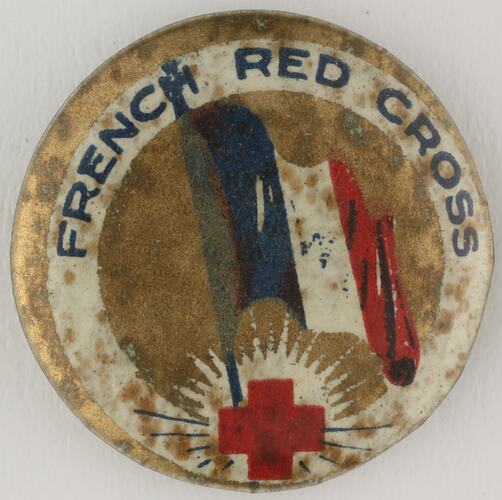 Round badge with French flag and red cross.