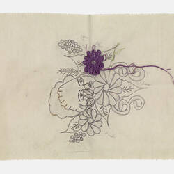 White fabric with drawn floral pattern below and around a face. One purple flower has been embroidered with it