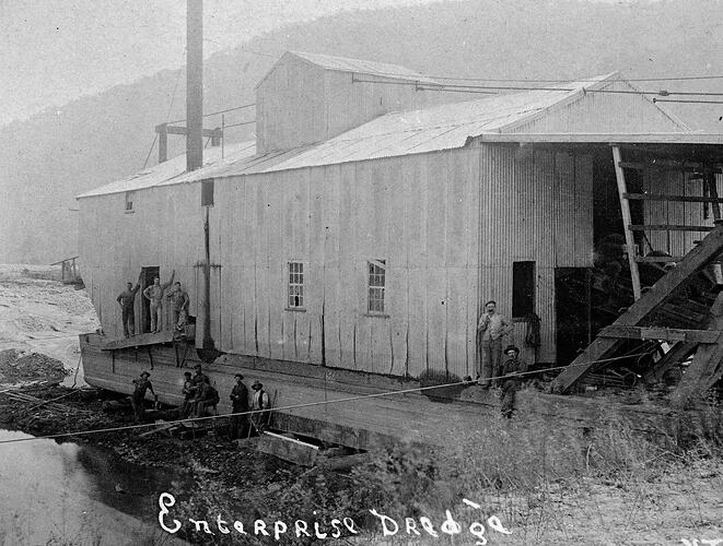 group of men with the steam-powered Enterprise bucket dredge. Water to the left.