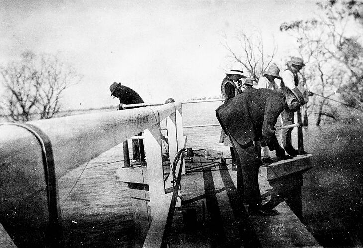 People fishing from the pier at a lake.