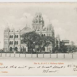 Three levelled grandiose building with arched windows. Domed tower at right side. Garden setting. Text at base