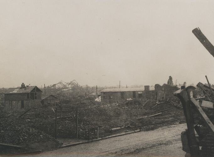 Scene of a destroyed city with two damaged buildings.