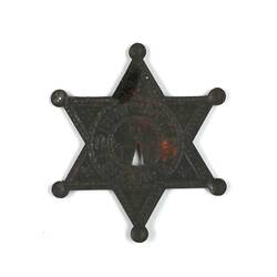 Back of six pointed toy metallic sheriff badge.