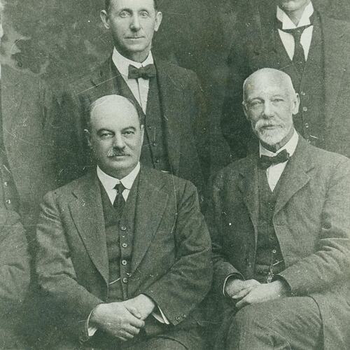 Cropped section of group portrait, men in suits.