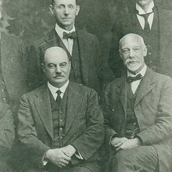 Cropped section of group portrait, men in suits.