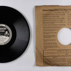 Black disc recording with printed paper sleeve.