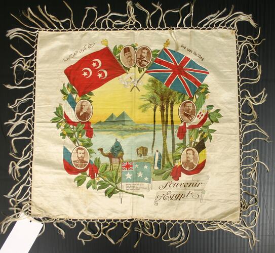 Fringed textile with flags around and scene within.