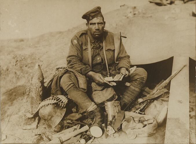 Soldier seated with kit and ammunition.