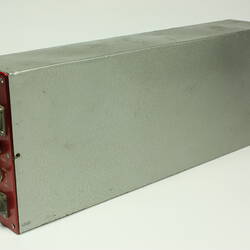 Red control panel with knobs and dials on front of metal box.