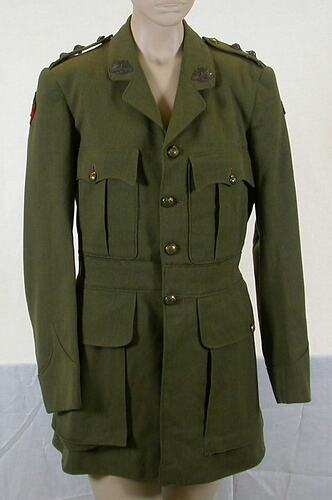 Khaki twill jacket. Two hip pockets with button flaps. Two breast pockets with pleat and button flaps.