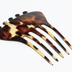 Tortoiseshell hair comb, five tines and knobs on base.