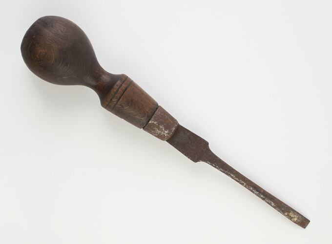 Chisel head screwdriver with wooden handle.