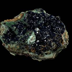 Blue crystals on green-stained rock.