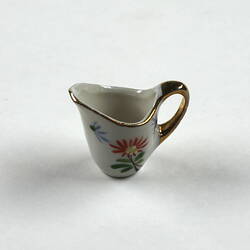 Tiny milk jug, handle right side.