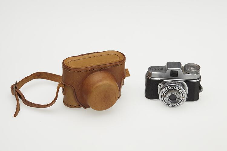 Miniature metal camera and brown case.