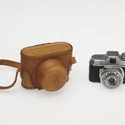 Miniature metal camera and brown case.