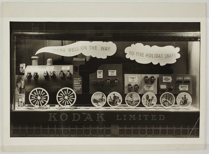 Window display of cameras and photographic equipment. Main body of display is a steam train.