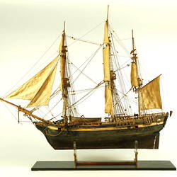 Wooden ship with three masts, facing left.