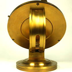 Rear view of gold metal chronometer.