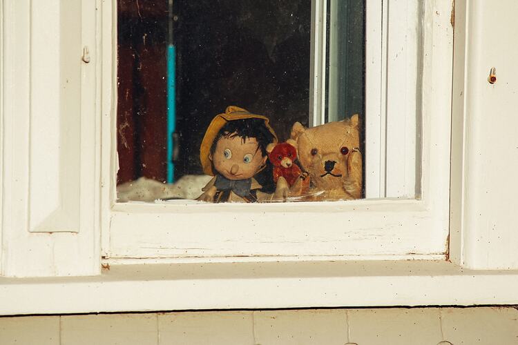 Pinocchio and teddies placed in window.