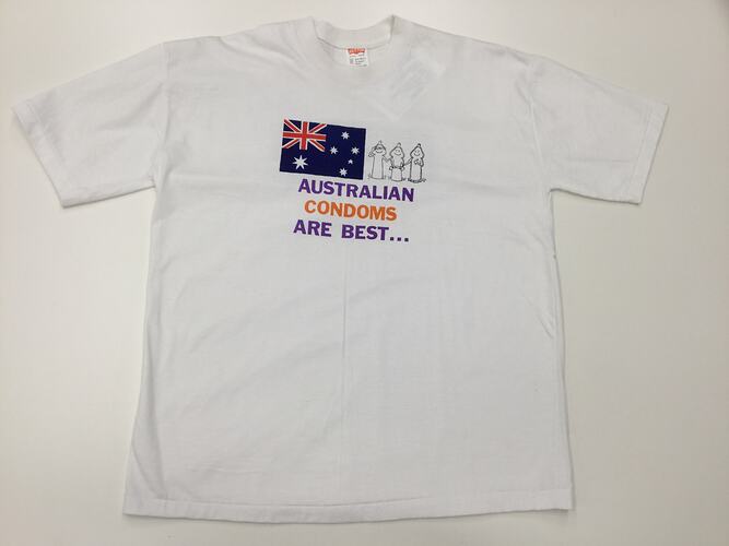 White t-shirt with Australian flag, three cartoon condoms, purple and orange text.