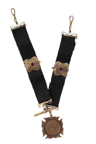 Metal fob suspended from two black ribbons, each with a central metal shield. Clip attachments at each end.
