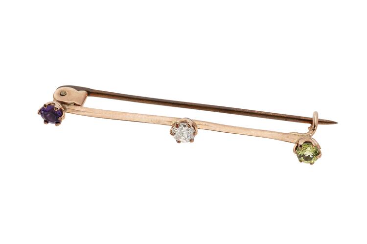 Rose gold bar brooch with three gemstones. Purple amethyst at left end, diamond in centre and light green peridot at right end.