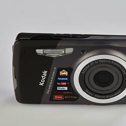 Black and grey camera with metal trim on back, sides and around the lens.