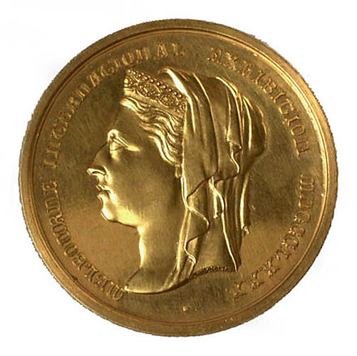 Round gold medal with female profile facing left,