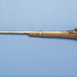 Single barrelled shotgun. Wooden half stock secured to barrel by a single band.