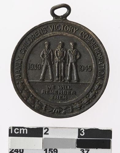 Round bronze medal with three men, text surrounding.