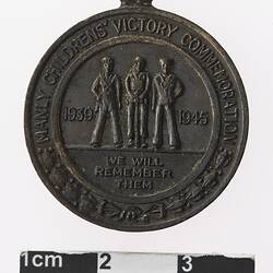 Round bronze medal with three men, text surrounding.