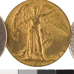 Round medal with winged woman and rainbow ribbon.
