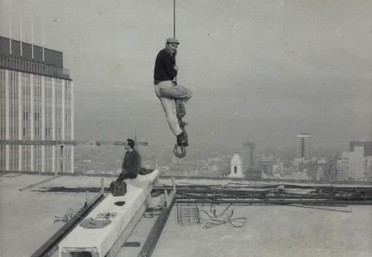 Digital Photograph - Man Swinging from Crane Hook, Reserve Bank Construction Site, showing Building, Melbourne, 1964