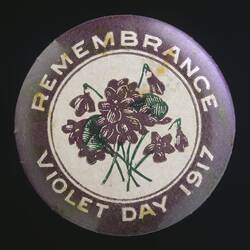 White and purple badge with flower and text.