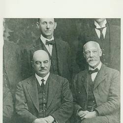 Cropped section of group portrait, men in suits.
