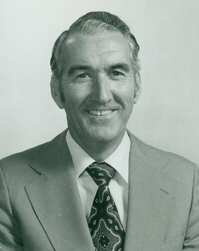 Studio portrait of a man wearing light colour suit and patterned tie.