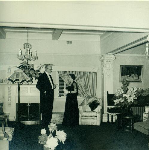 Man and woman standing in front of fireplace in lounge room.