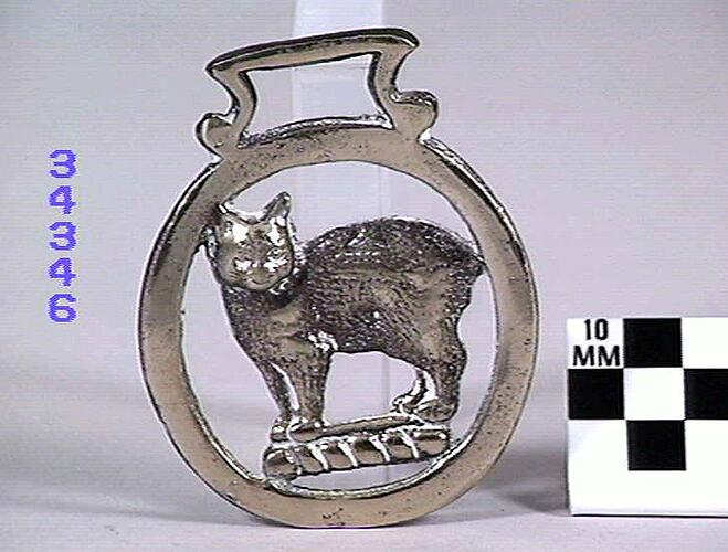 Big metal ring with metal cat inside the ring.